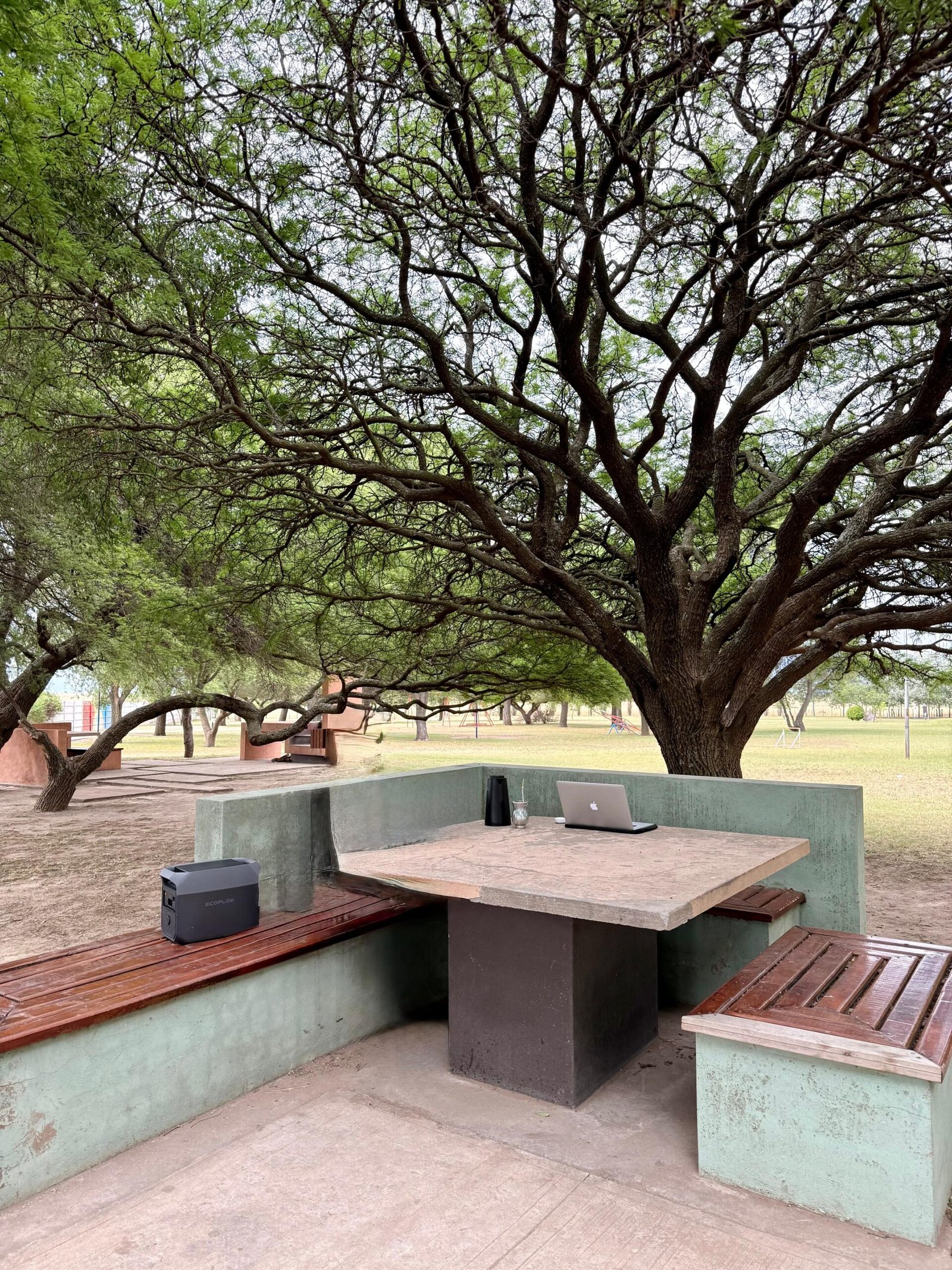 Área de lazer com churrasqueiras de concreto e mesas sob as árvores no Parque de la Salud em Colonia Santa María La Pampa.